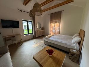 a bedroom with a bed and a table and a tv at Zakątek nad Wkrą in Goławice +15 photos