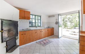 una cocina con armarios de madera y una puerta abierta en Awesome Home In Palazzolo Acreide, en Palazzolo Acreide