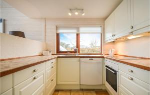 a kitchen with white cabinets and a window at Three-Bedroom Holiday Home In Ebeltoft in Ebeltoft