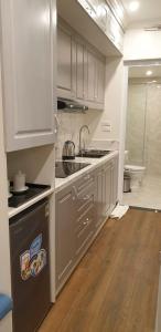 a kitchen with white cabinets and a sink at Gia Hưng Khang Hometel in Ha Long