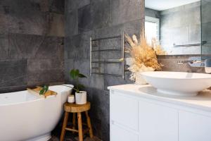 a bathroom with a white tub and a sink at Bawley Beach Escape in Bawley Point +22 photos