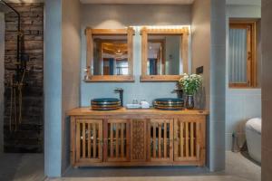 丽江夕露古城中心店 XILU INN NANXI - Ancient City Center Branch的浴室设有木制梳妆台、两个盥洗盆和镜子