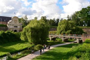 un gruppo di persone che vanno in bicicletta su un sentiero in un parco di Maison à l'orée du BOIS CITADELLE de LILLE avec TERRASSE en plein sud PROCHE DE TOUTES COMMODITES à la porte de LILLE a Lambersart