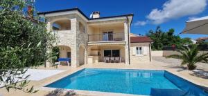 eine Villa mit einem Swimmingpool vor einem Haus in der Unterkunft Luxury five stars villa with pool, near beach - by TRAVELER tourist agency Krk - ID 2140 in Pinezici