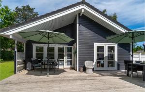 a patio with tables and chairs and umbrellas at Gorgeous Home In Samsø With Kitchen in Onsbjerg +13 photos