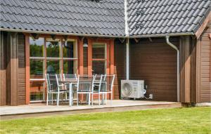 a house with a deck with a table and chairs at Holiday Home Brombærvej Xi in Lem