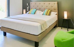 a bedroom with a large bed and a green chair at Cozy Home In Maillane With Kitchen in Maillane