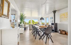 a dining room and living room with a table and chairs at Pet Friendly Home In Allinge With Wifi in Allinge