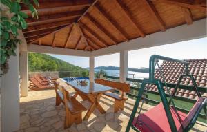 patio z drewnianym stołem i krzesłami na tarasie w obiekcie Two-Bedroom Apartment Karbuni With Sea View 09 w mieście Prižba +29 zdjęć