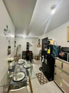 a kitchen with a glass table and a refrigerator at Affordable Condotel in Cebu in Cebu City +14 photos