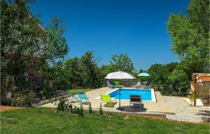 a swimming pool with chairs and an umbrella at Villa May in Poreč