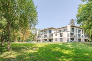a large white building with a large yard at Gelassenheit - modernes Apartment am Krakower See in Krakow am See