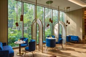 a restaurant with blue chairs and tables and large windows at InterContinental Taichung by IHG in Taichung