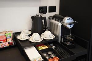 a table with plates and cups and a coffee maker at No Man's Land Guesthouse in Rome