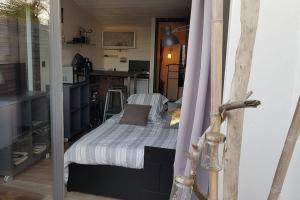 a small bedroom with a bed and a kitchen at Le cocon de la plage du Santocha in Capbreton +11 photos