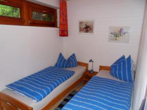 クックスハーフェンにあるFerienhaus von Bargenの青い枕が備わる客室内のベッド2台