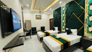 a hotel room with two beds and a flat screen tv at Hotel Breezy Lahore in Lahore