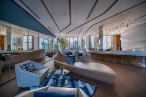 a lobby with chairs and a couch and a table at Hotel Baraquda Heeton Pattaya by Compass Hospitality in Pattaya Central