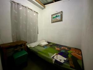 a small bedroom with a bed and a window at Punta Landing Travellers Inn in Surallah