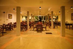 a restaurant with tables and chairs in a room at Lake Wind Resort in Tissamaharama