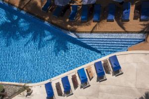 an overhead view of a swimming pool with blue chairs at Hotel Baraquda Heeton Pattaya by Compass Hospitality in Pattaya Central