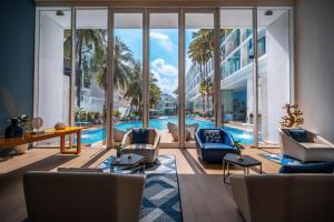 a living room with a swimming pool and a large window at Hotel Baraquda Heeton Pattaya by Compass Hospitality in Pattaya Central +98 photos