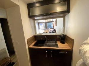 a small kitchen with a sink and a window at Appt Cosy au centre Chamonix in Chamonix
