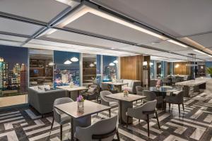 a restaurant with tables and chairs and a city skyline at InterContinental Taichung by IHG in Taichung