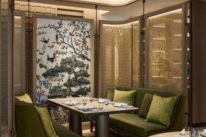 a dining room with a table and green chairs at InterContinental Taichung by IHG in Taichung