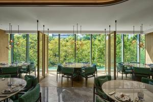 a dining room with tables and chairs and large windows at InterContinental Taichung by IHG in Taichung
