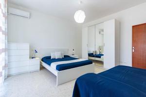 een witte slaapkamer met 2 bedden en een spiegel bij Appartamento Bellariva B1-MyHo Casa in Porto San Giorgio