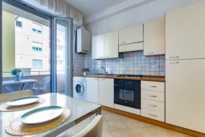 een keuken met witte kasten en een aanrechtblad bij Appartamento Bellariva B1-MyHo Casa in Porto San Giorgio