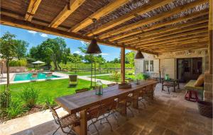 an outdoor patio with a wooden table and a pool at Villa Catalpa in Poreč