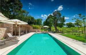 a swimming pool with an umbrella and chairs and an umbrella at Villa Catalpa in Poreč