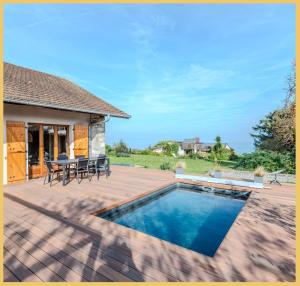 eine Terrasse mit Pool und Tisch und Stühlen in der Unterkunft La Maison du Lac I Excenevex in Excenevex