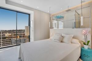 sypialnia z białym łóżkiem i dużym oknem w obiekcie Exclusivo apartamento con increíbles vistas al mar w mieście Torremolinos +37 zdjęć