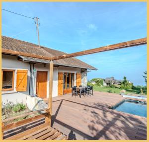 eine Terrasse mit einem Tisch, Stühlen und einem Pool in der Unterkunft La Maison du Lac I Excenevex in Excenevex