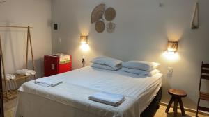 a bedroom with a bed with towels on it at Vila Ybirá in Taíba