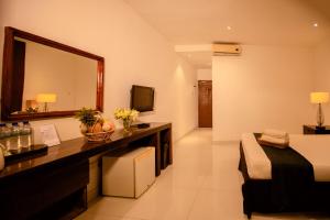 a hotel room with a bed and a mirror at Lake Wind Resort in Tissamaharama