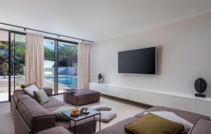 a living room with a couch and a tv on a wall at Villa Amber in Pakoštane