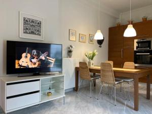 a living room with a television and a dining room table at Casa Ourania in Farsala