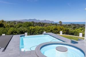 a pool on a patio with a view of the ocean at Waveren's Nest in Cape Town
