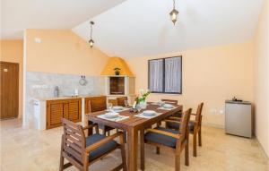 kuchnia i jadalnia z drewnianym stołem i krzesłami w obiekcie Gorgeous Home In Divsici With Wifi w mieście Divšići