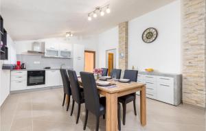 kuchnia i jadalnia z drewnianym stołem i krzesłami w obiekcie Gorgeous Home In Divsici With Wifi w mieście Divšići