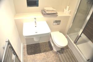 a small bathroom with a sink and a toilet at Brentwood Town Retreat - Large 2 bedroom apartment in Brentwood