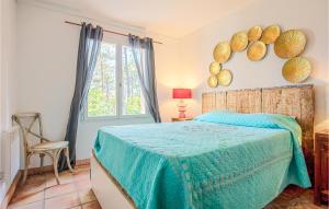a bedroom with a bed with a blue blanket and a window at Beautiful Home In Les Arcs With Wifi in Trans-en-Provence