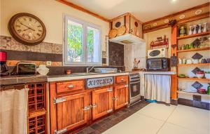 a kitchen with wooden cabinets and a clock on the wall at Beautiful Home In Les Arcs With Wifi in Trans-en-Provence