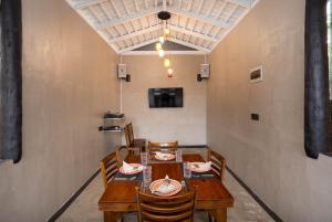 a dining room with a wooden table and chairs at Hasthri Boutique Brown Apartment in Ahangama with pool Near Beach in Ahangama