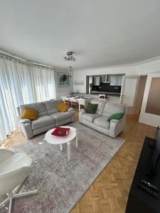 een woonkamer met twee banken en een tafel bij Très belle appartement proche du centre de Bruxelles in Brussel