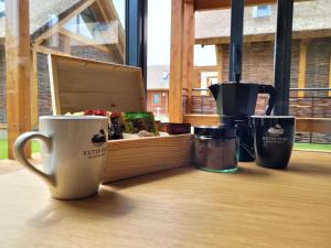 a table with coffee cups and a box on it at Domki Kuter Port in Gdów